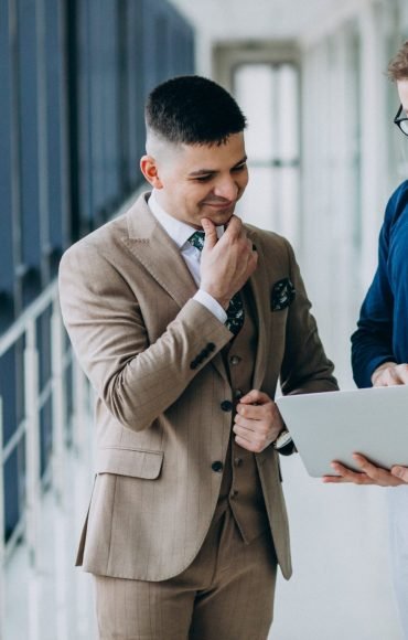 two-male-colleagues-office-standing-with-laptop (2)-min